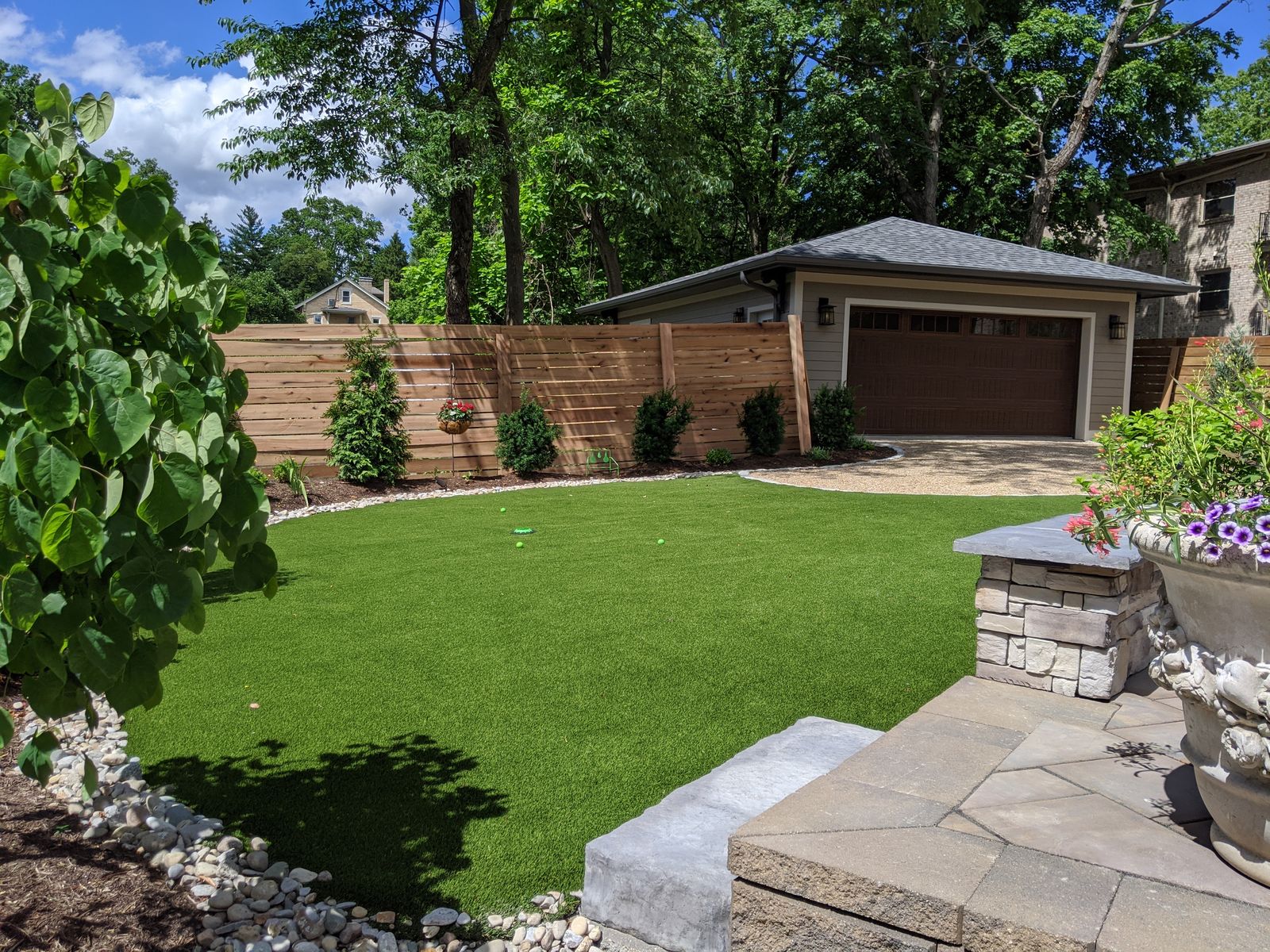 Fresh lawn framed by planting beds and horizontal cedar fencing