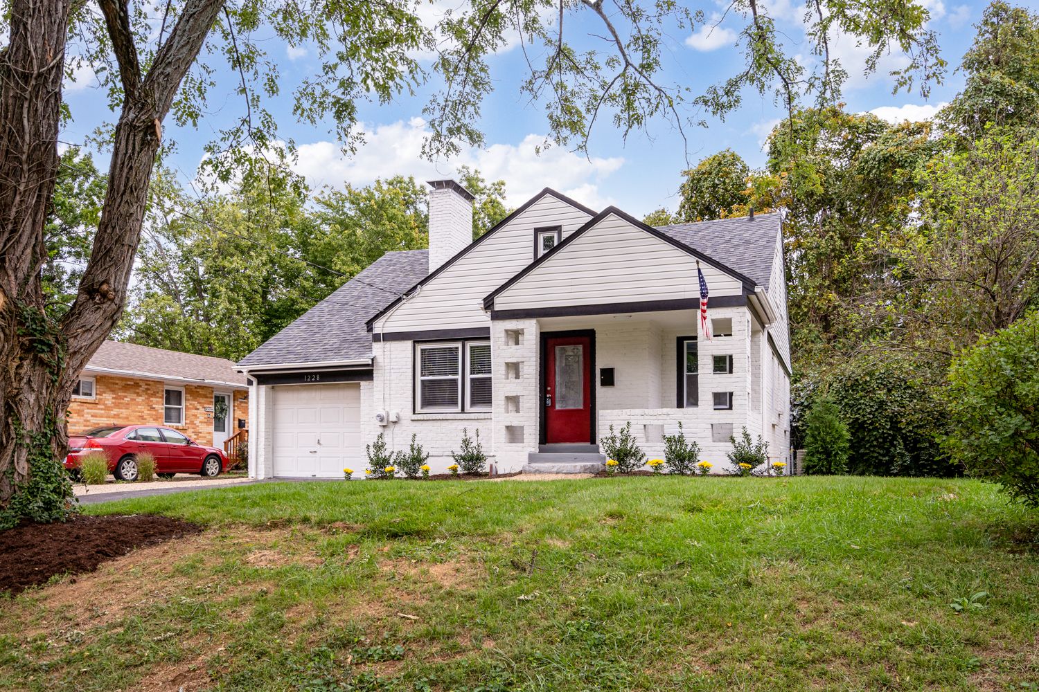 Renovated cottage front exterior with white painted brick and red front door