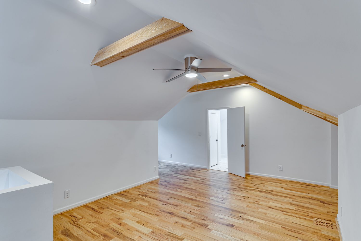 Vaulted upstairs suite with exposed wood beams and hardwood floors