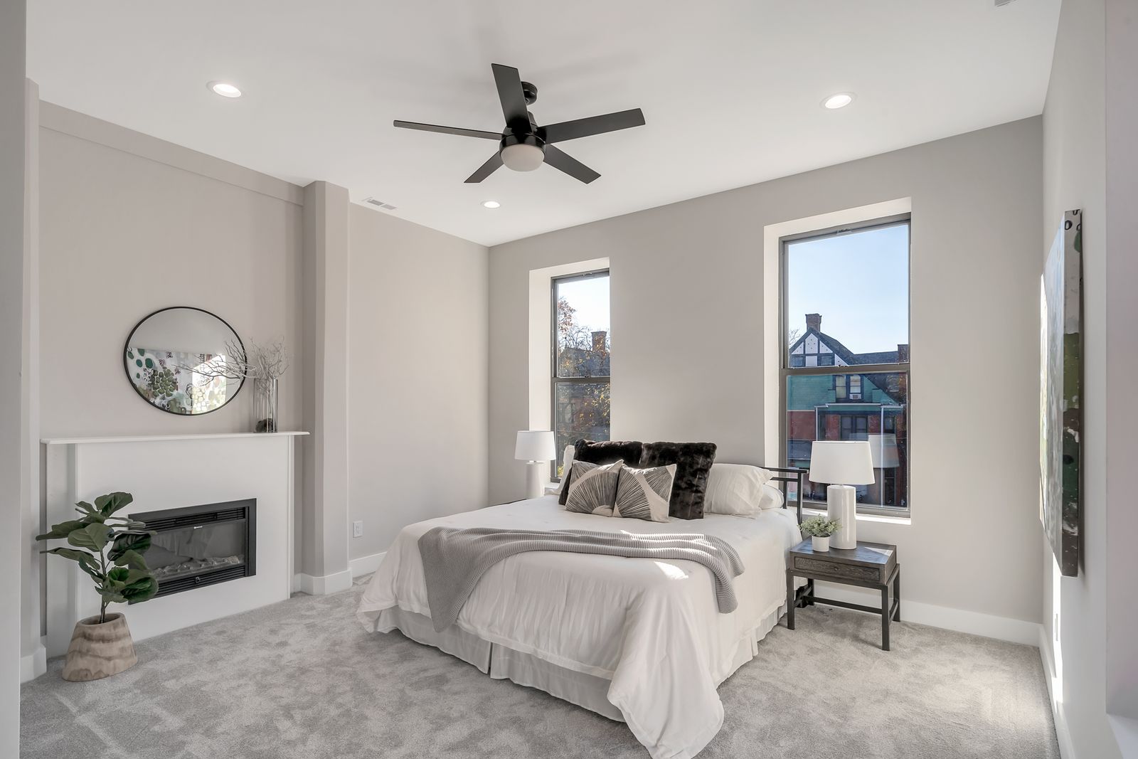 Bedroom with modern linear fireplace and tall windows