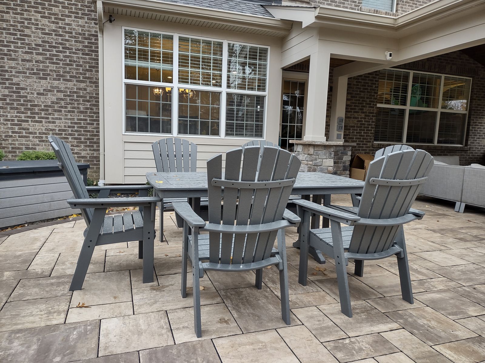Paver patio with outdoor dining set beside the covered porch