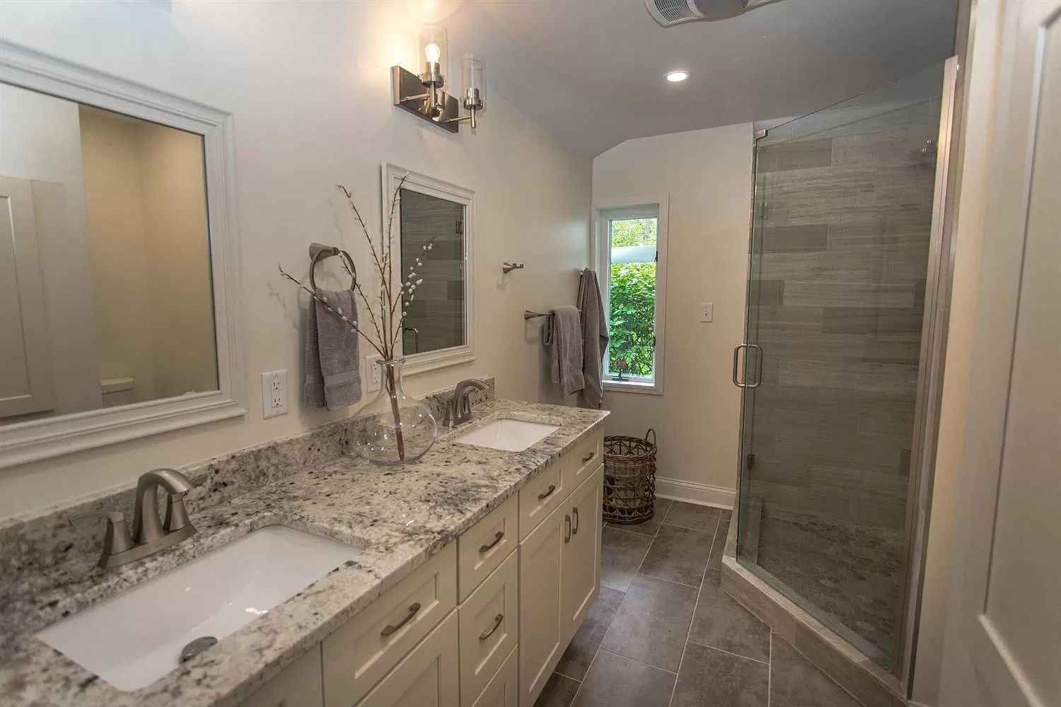 Renovated master bath with double granite vanity and walk-in tile shower