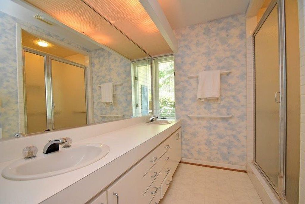 Dated master bath vanity with floral wallpaper before renovation