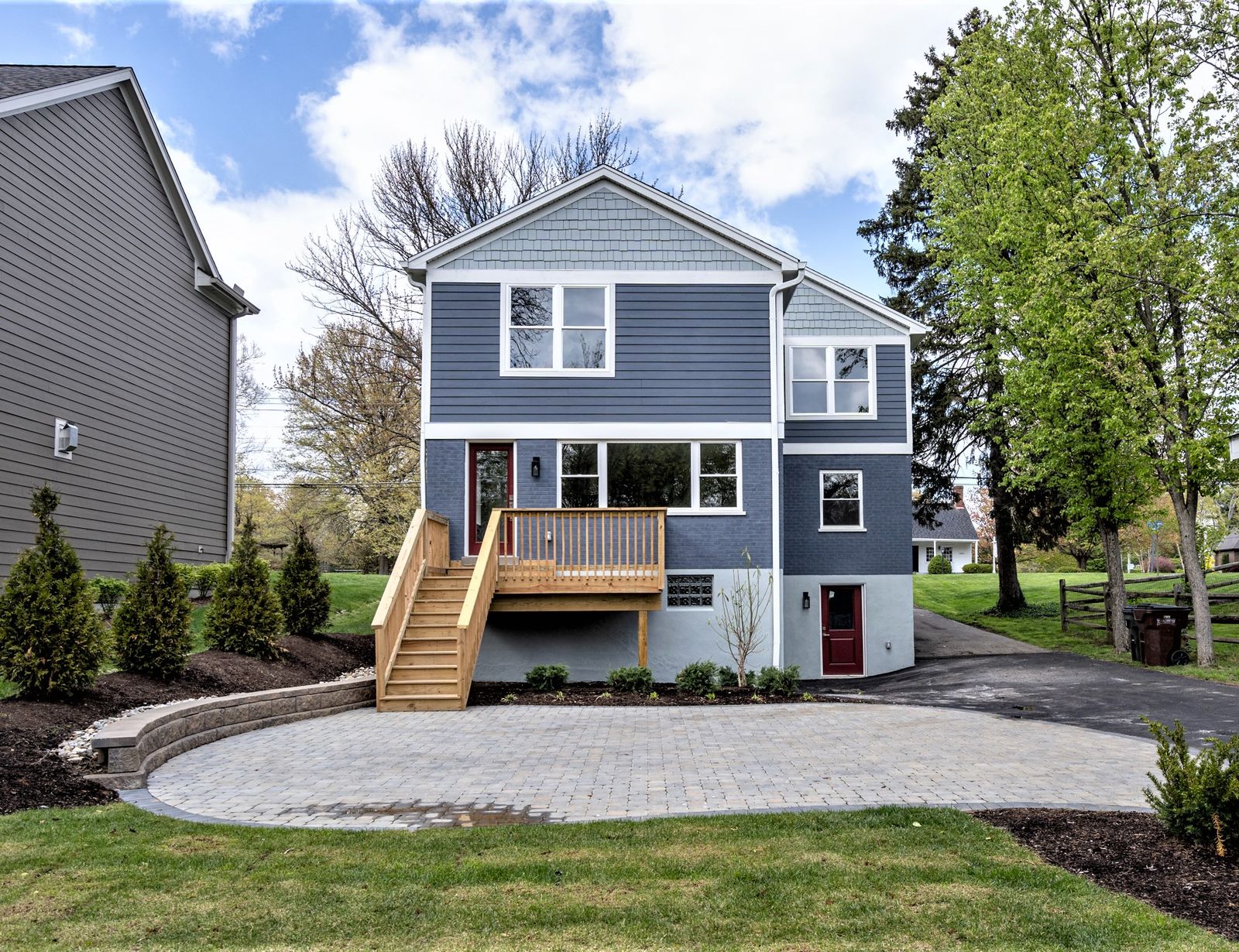 Rear exterior with wood deck, paver patio, and walk-out lower level