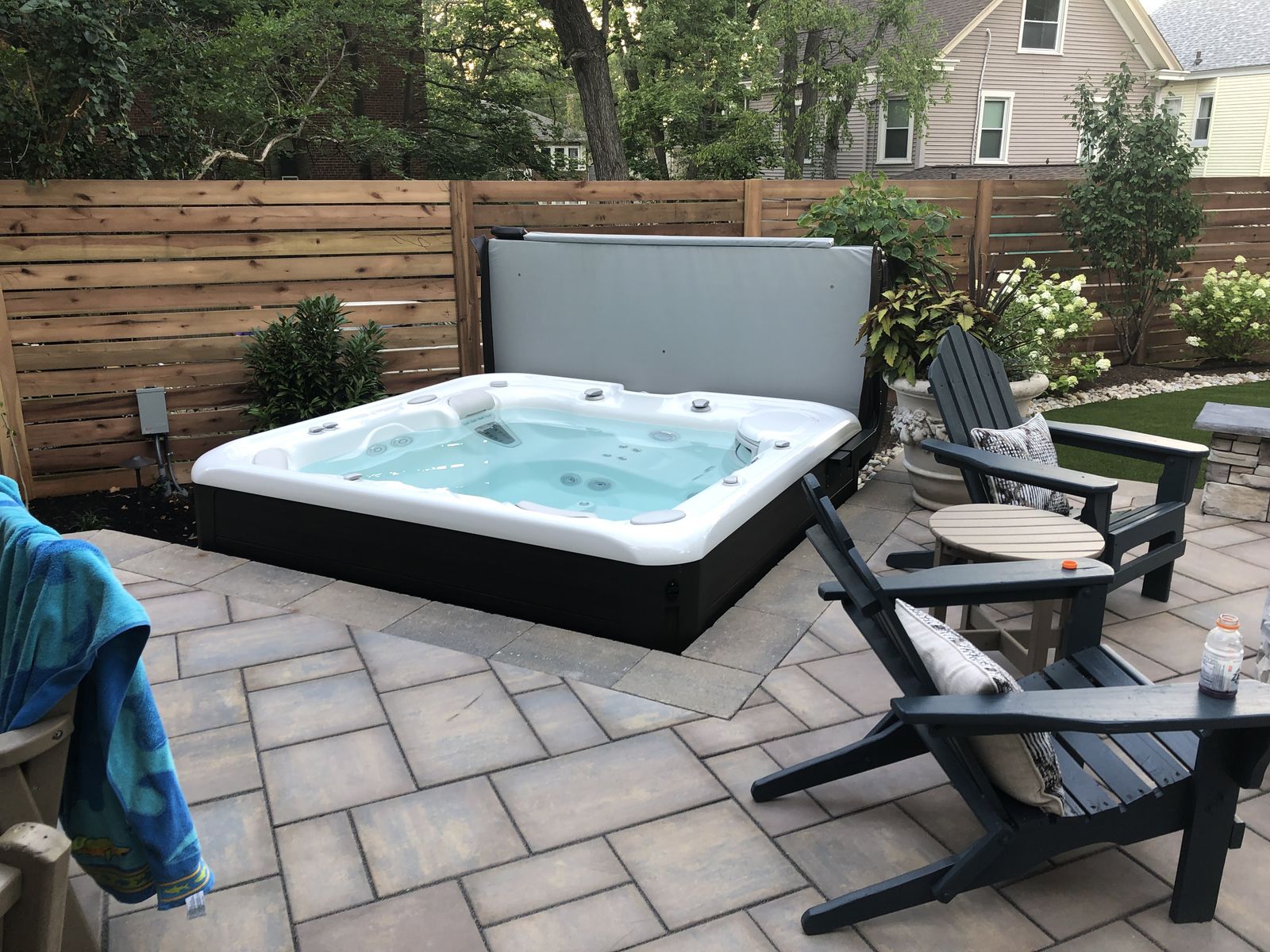 Built-in hot tub beside a fire pit and covered porch