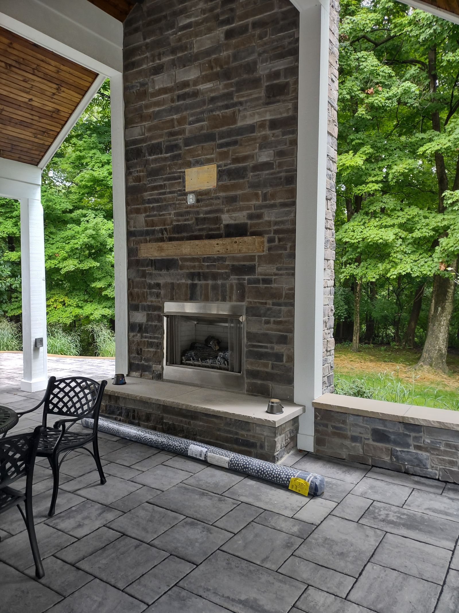 Covered porch dining area with brick fireplace