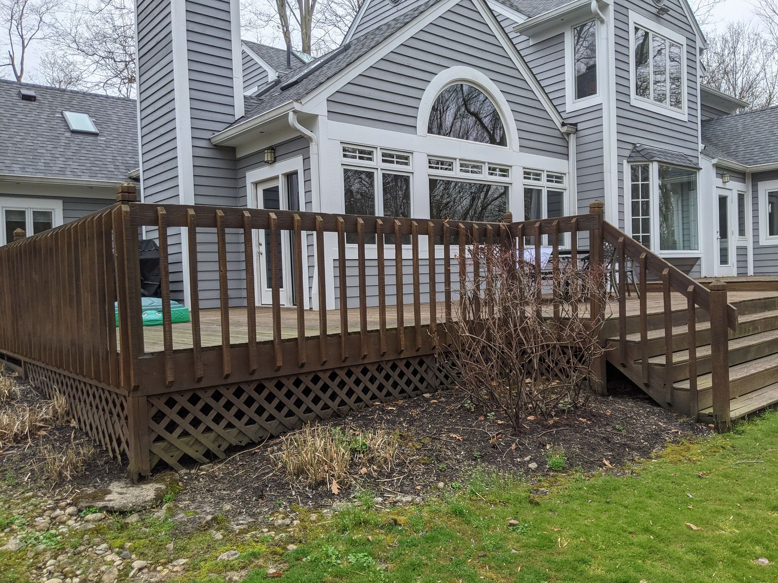 Old wood deck with railings and lattice skirting before replacement