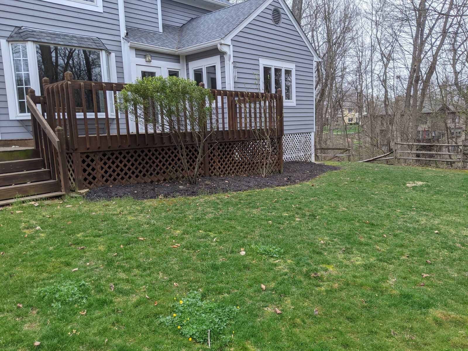 Side yard view of weathered wood deck before porch addition