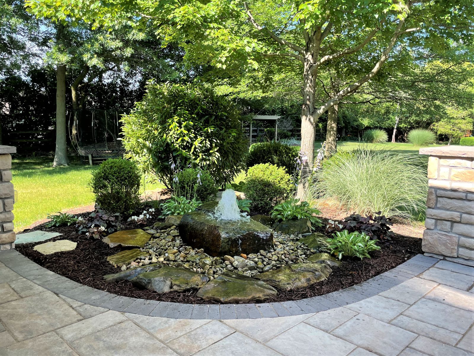 Bubbling boulder water feature in a landscaped bed