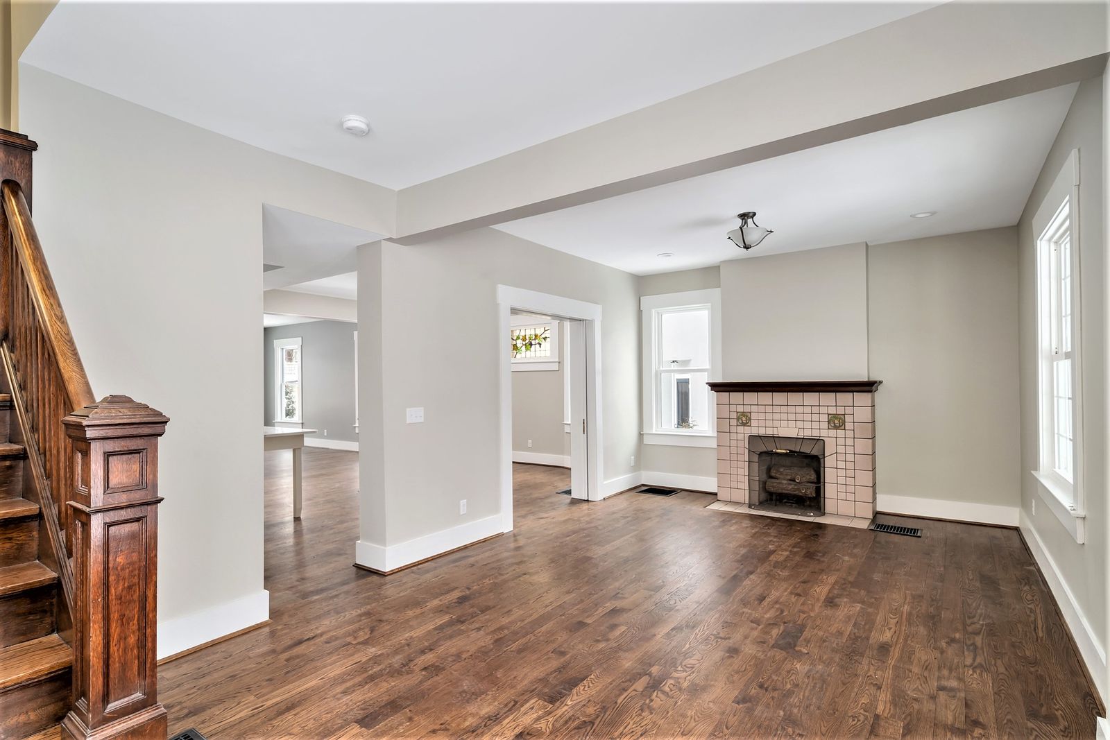 Renovated living room with original tile fireplace and refinished hardwood floors