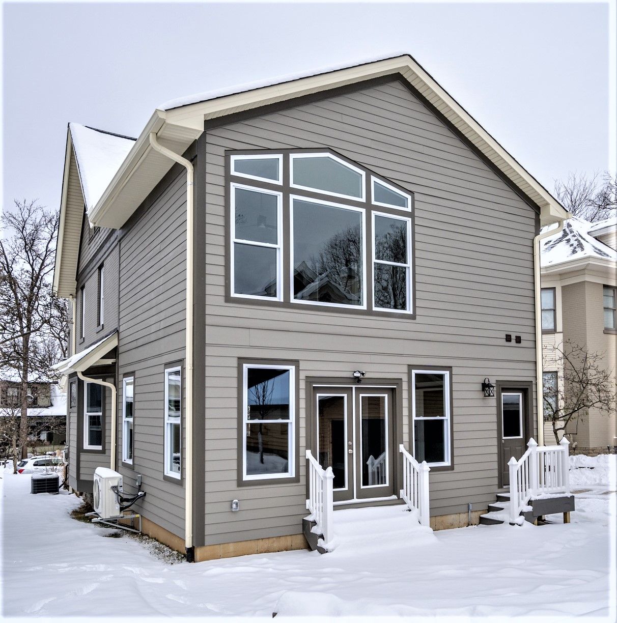 Renovated rear exterior with large feature windows and new siding